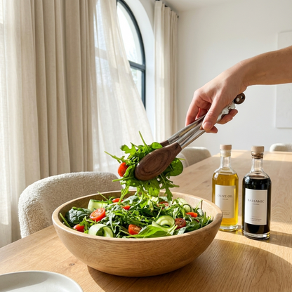 Stainless steel and wood tongs serving salad in wooden bowl