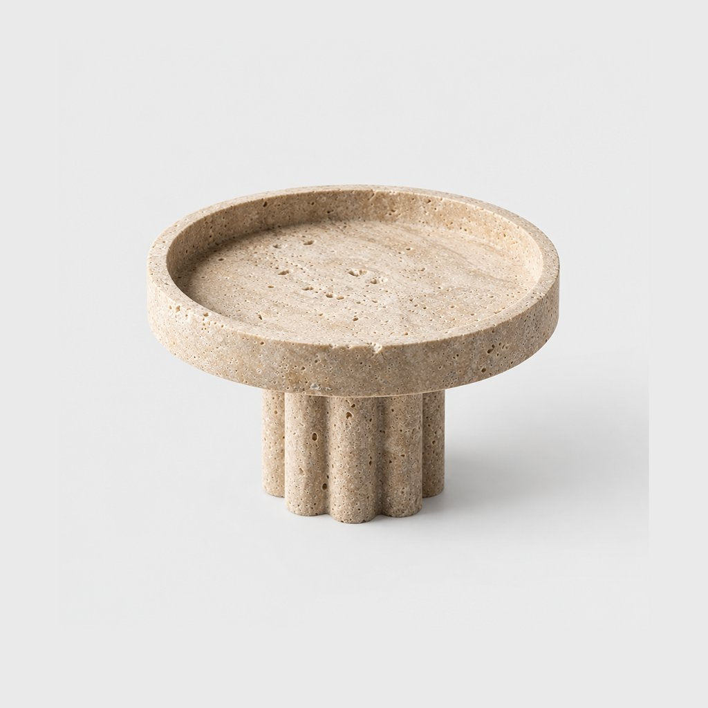 Empty round pale beige pedestal tray with a low rim on a fluted column base, on a plain light gray background