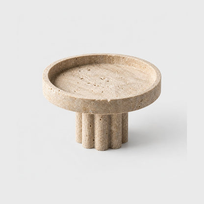 Empty round pale beige pedestal tray with a low rim on a fluted column base, on a plain light gray background