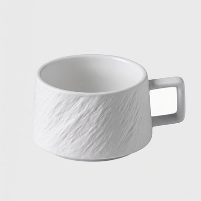 White textured ceramic cup on a plain light background