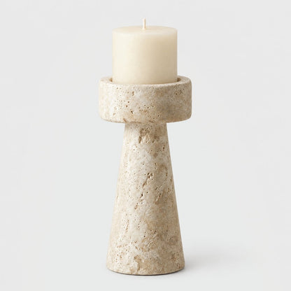 Large cream travertine pillar candleholder with a cream pillar candle on a light grey background
