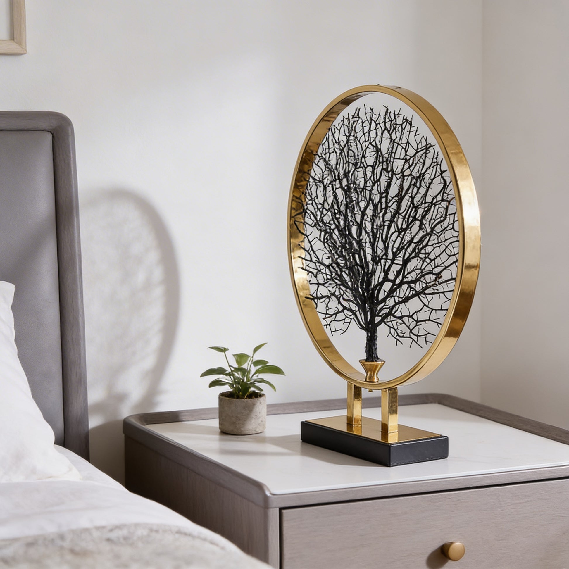 black coral sculpture inside gold circular frame