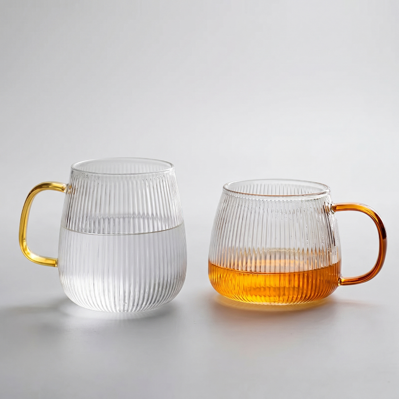 Set of ribbed glass mugs with amber and clear drinks on white background