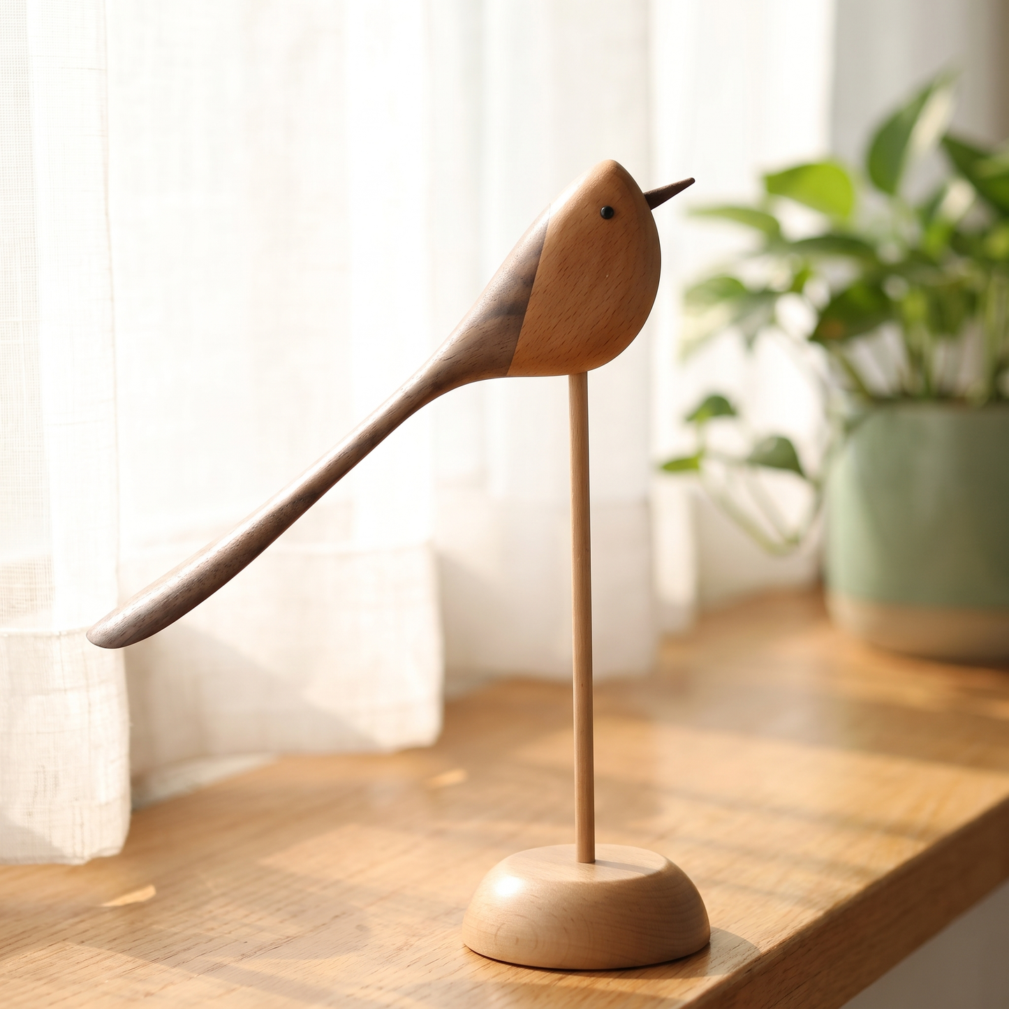 Two-Tone Wood Bird Sculpture on a bright windowsill with sheer curtains and a potted plant