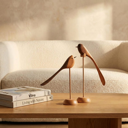 Two-Tone Wood Bird Sculptures on a wood table with books in front of a boucle sofa