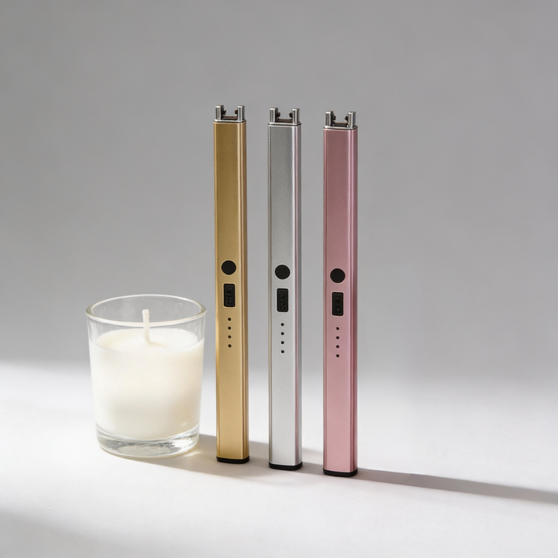 Three electronic devices in gold, silver, and pink next to a candle on a gray background