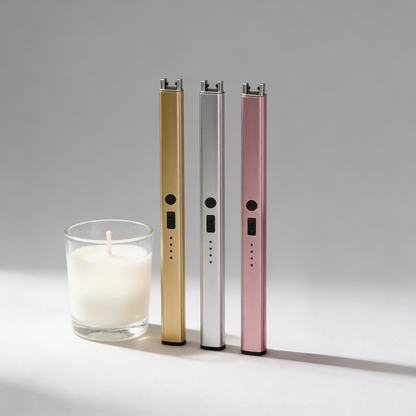 Three electronic devices in gold, silver, and pink next to a candle on a gray background
