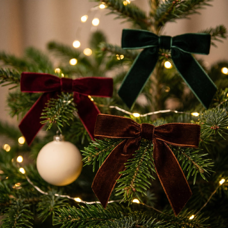 Velvet bow on Christmas tree branch with ornaments