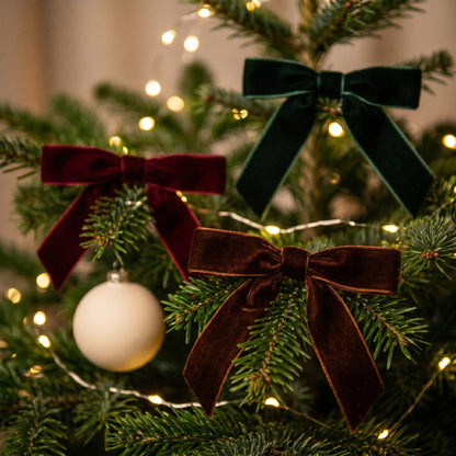 Velvet bow on Christmas tree branch with ornaments