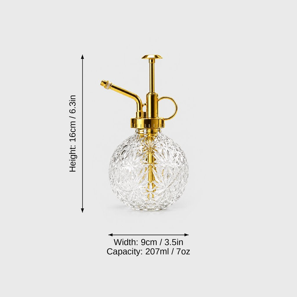 Clear cut glass plant mister with gold pump top on a light grey background with dimensions labeled Height 16 cm or 6.3 in, Width 9 cm or 3.5 in and Capacity 207 ml or 7 oz