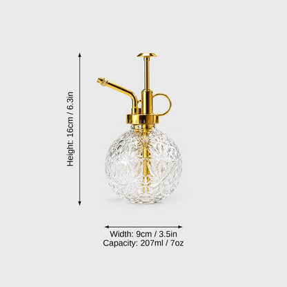 Clear cut glass plant mister with gold pump top on a light grey background with dimensions labeled Height 16 cm or 6.3 in, Width 9 cm or 3.5 in and Capacity 207 ml or 7 oz