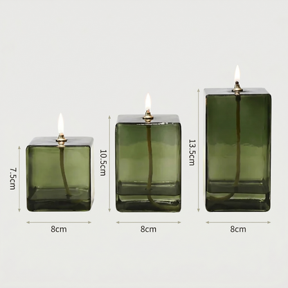 Three green glass candle holders with dimensions on a white background