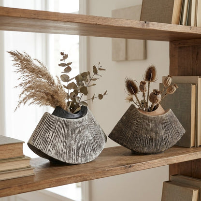 Black and brown WabiSabi Ceramic Vases with dried florals displayed on a bookshelf