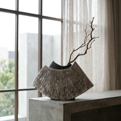 Black WabiSabi Ceramic Vase with a single dried branch displayed on a concrete pedestal near a window