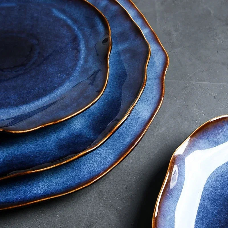 Set of Wave Dinnerware including plates and bowls, featuring the unique irregular shapes and glossy ceramic finish.