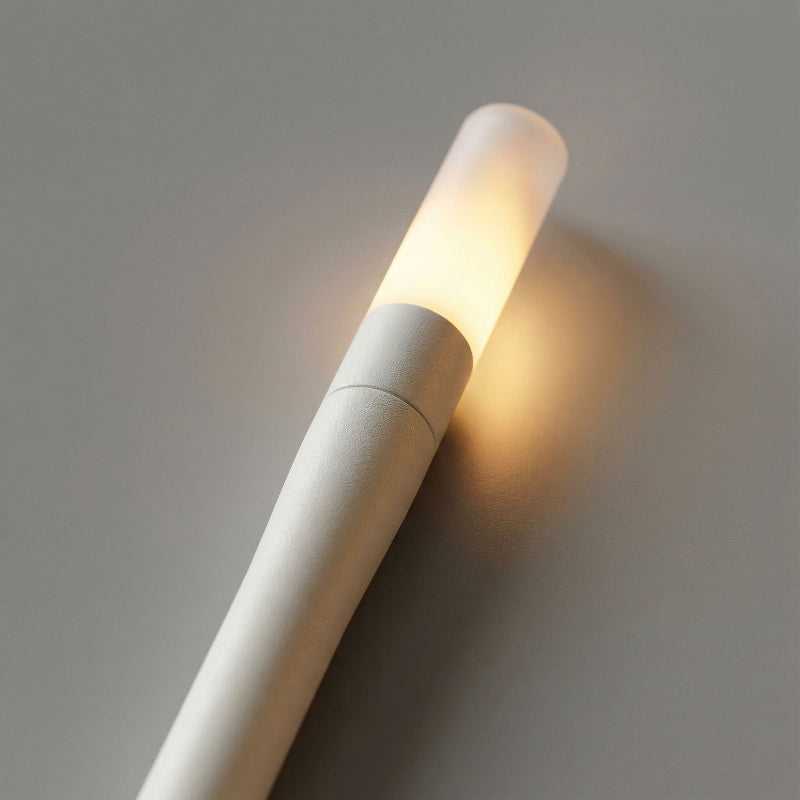 Wall-mounted light fixture casting a warm glow on a neutral background