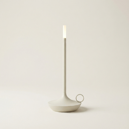 Minimalist candle holder with a candle on a plain background