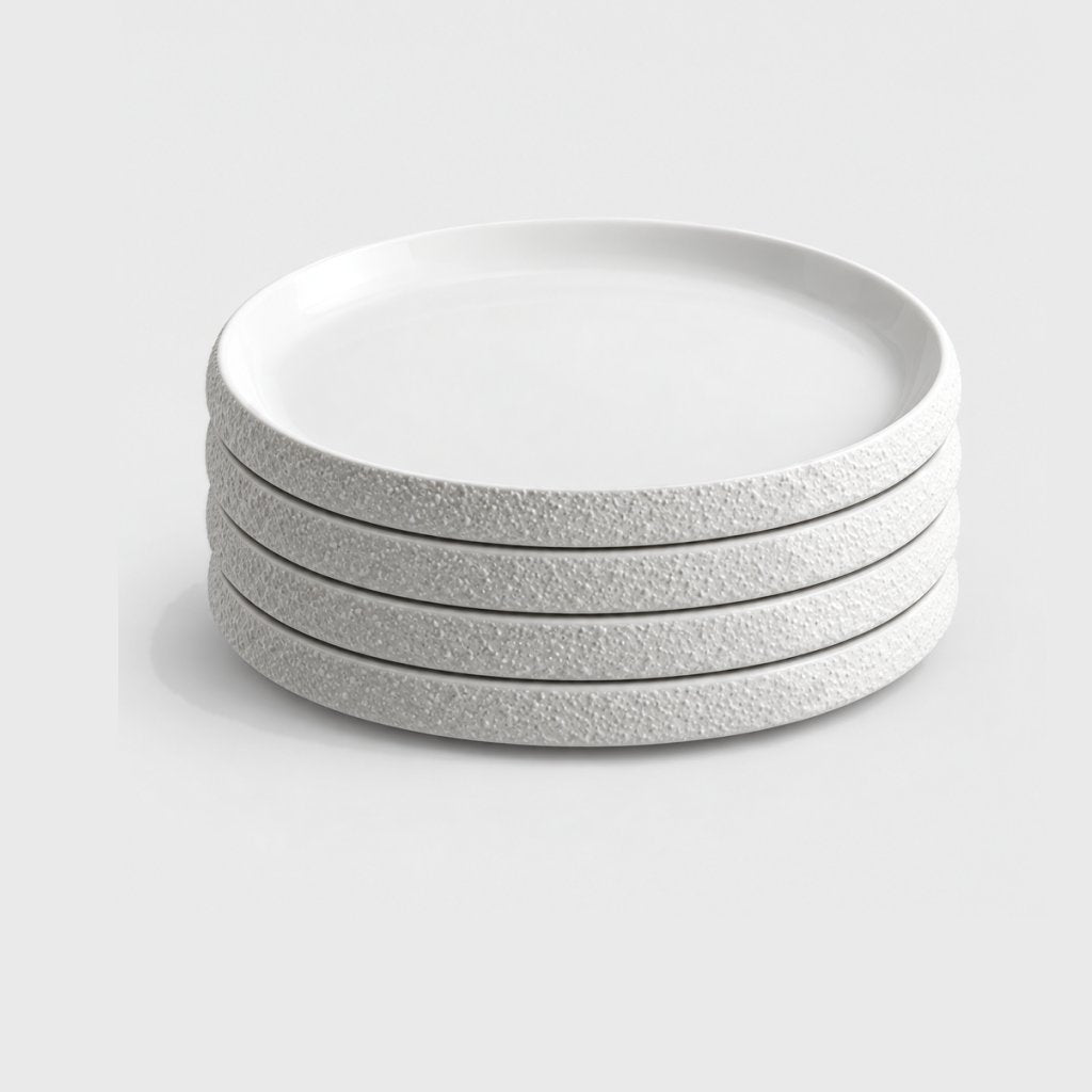Stack of four white textured ceramic plates on a plain light background