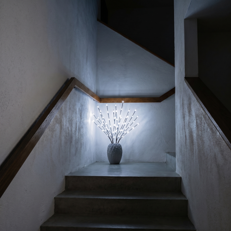 Willow branch LED lights in white vase on staircase landing