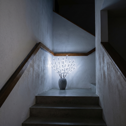 Willow branch LED lights in white vase on staircase landing
