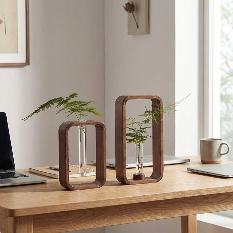 Wooden desk with decorative vases and a laptop in a bright room.