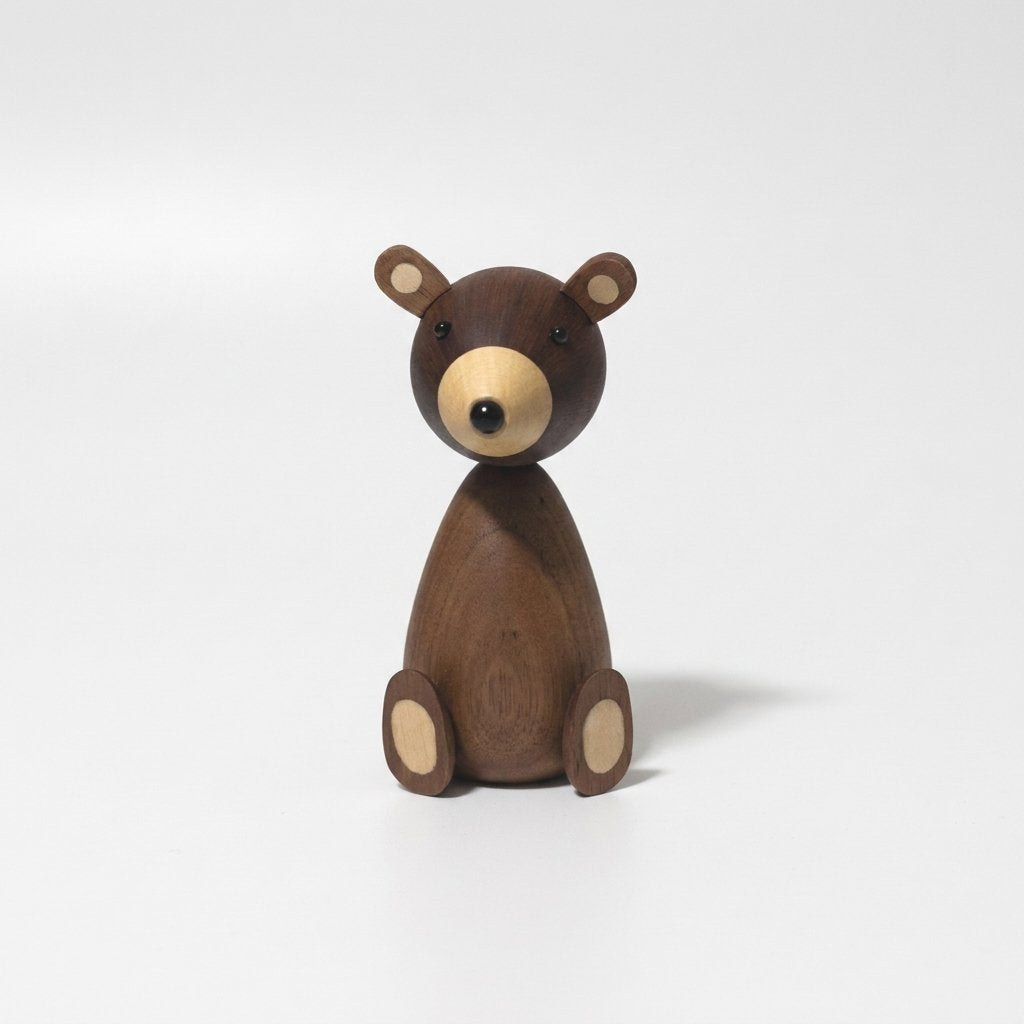 Small walnut-finish wooden bear figurine with a pale muzzle and ear inlays on a plain light background