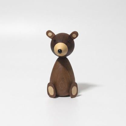 Small walnut-finish wooden bear figurine with a pale muzzle and ear inlays on a plain light background
