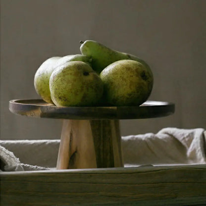 Wooden Cake Stand displayed outdoors on a table, elegantly holding fresh fruit for a casual gathering.