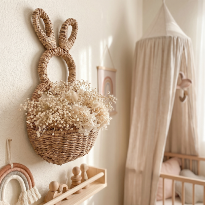 Woven bunny wall basket on wall beside chair in soft neutral room