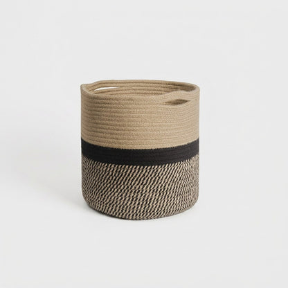 Woven Storage Basket in black and tan two-tone cotton rope with handles, hero shot on a clean off-white background