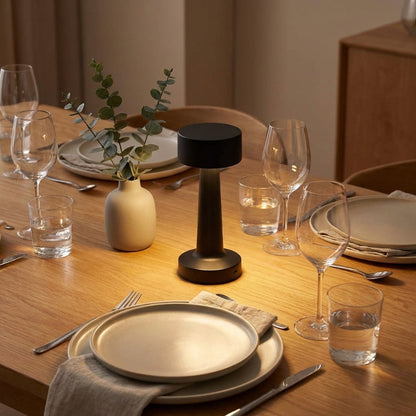Zain cordless rechargeable table lamp in black on dining table with plates and glassware