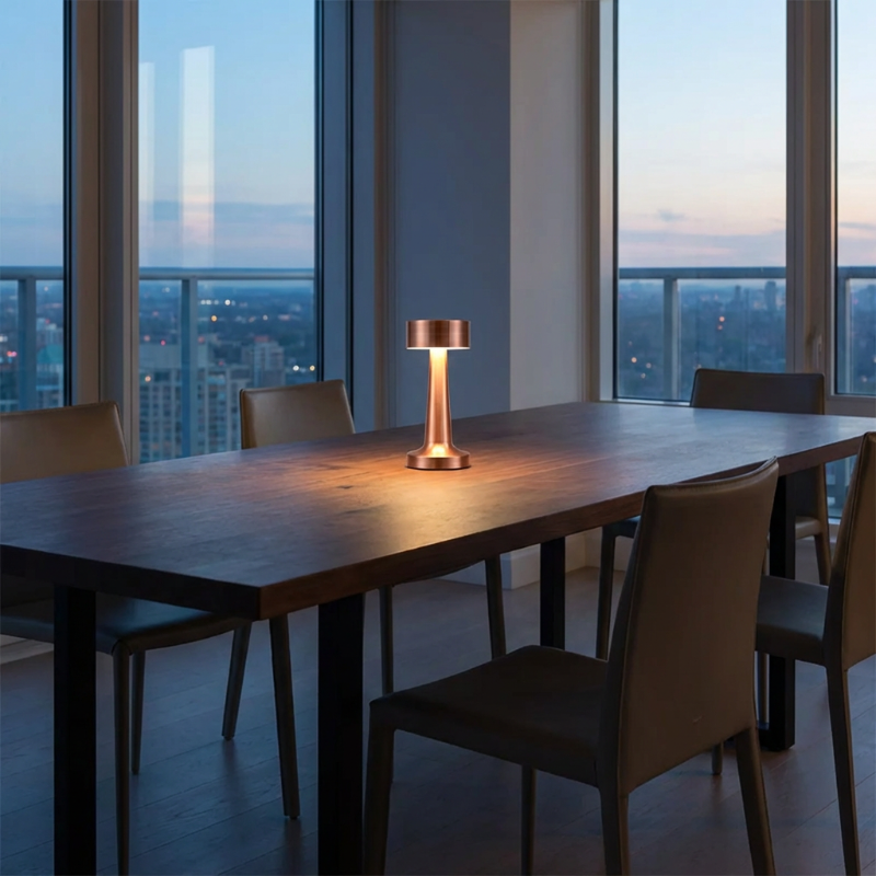 Zain cordless rechargeable table lamp in rose gold on outdoor dining table with wine glasses