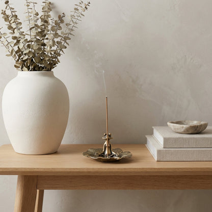Zen frog figurine styled with ceramic vase and dried stems