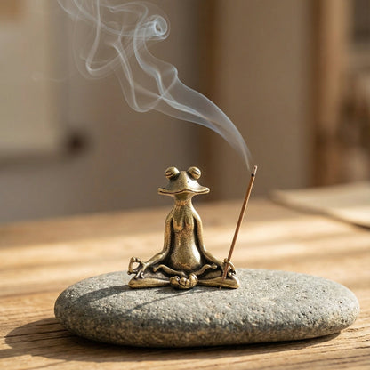 Bronze frog incense burner with smoking incense on a stone base