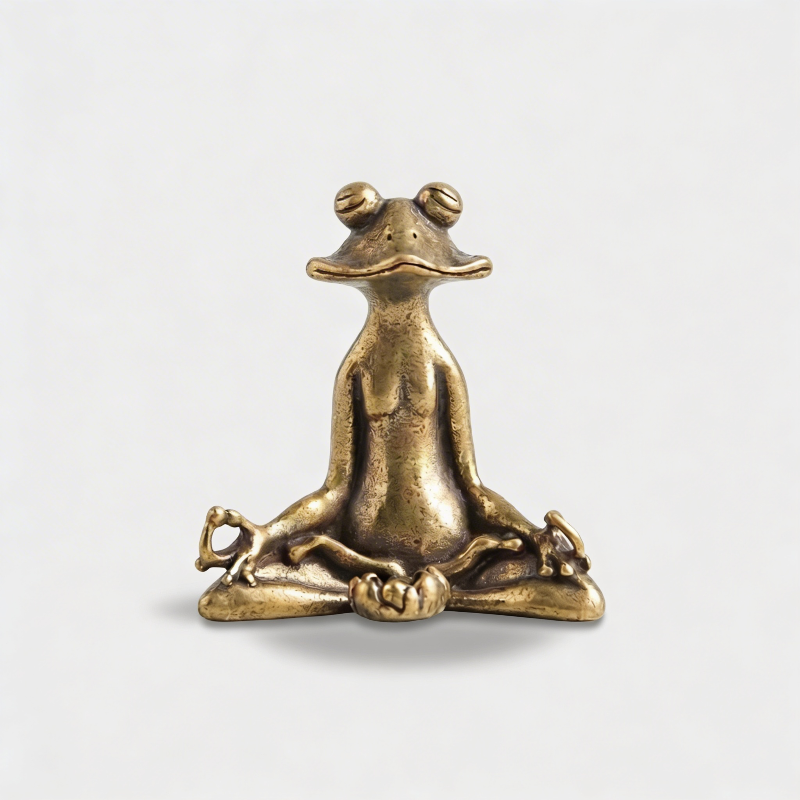 Zen frog figurine in antique brass finish on white background